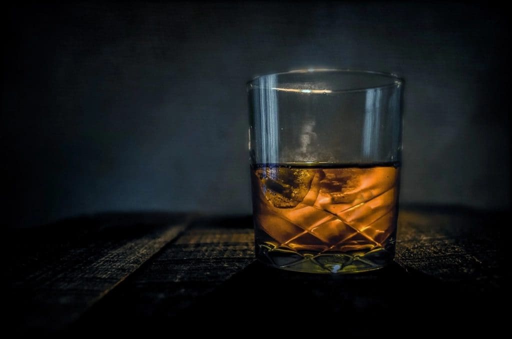Szklanka whisky z lodem na ciemnym stole