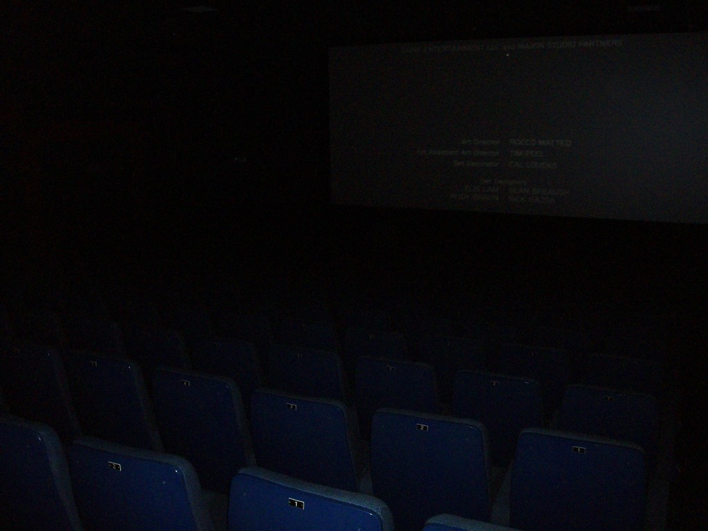 Pusta sala kinowa z napisami końcowymi na ekranie — źródło wyobrażeń o hipnozie